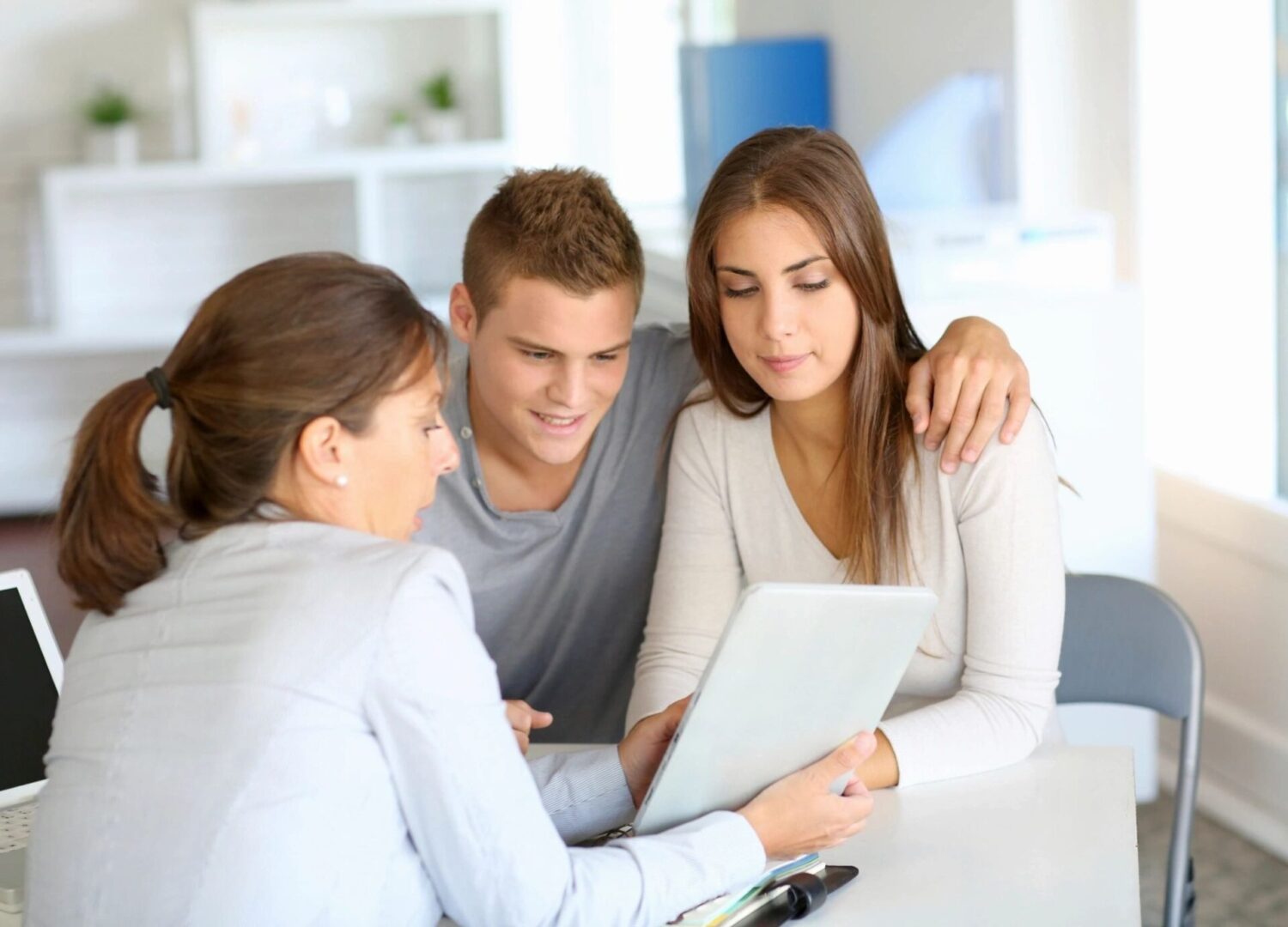 A couple of people that are looking at something on the laptop