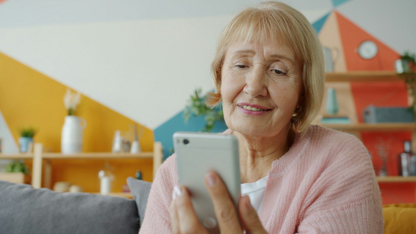 Smiling senior woman looking at her phone